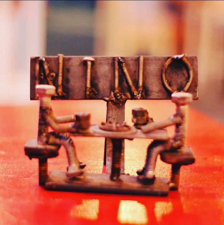 Escultura artesanal con el nombre Nino sobre una mesa del local